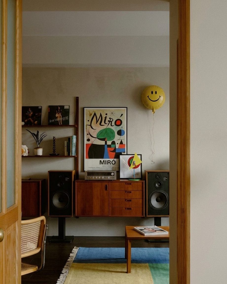 Rincón con mueble de madera, afiche y objetos de color